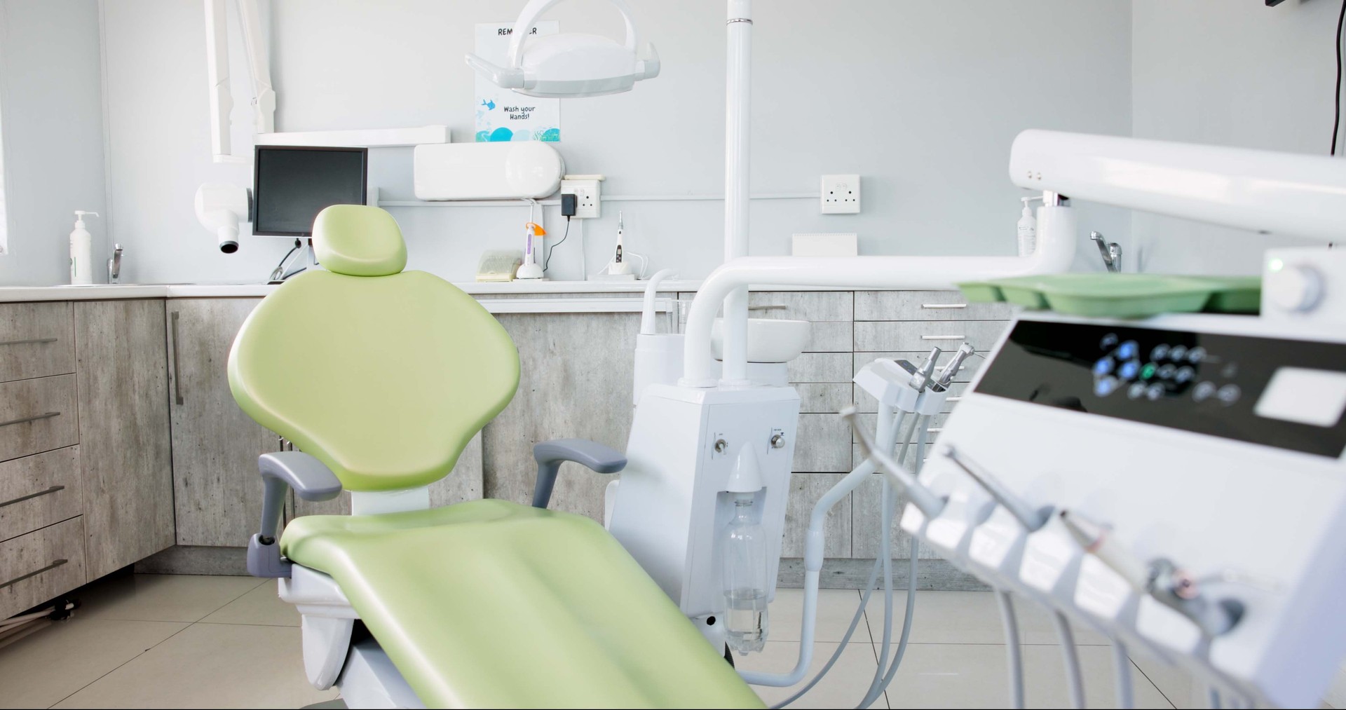 Empty dentist room, chair and equipment for cleaning, wellness and oral health with tools in clinic. Hospital, dental and mouth care by furniture, machine or interior for teeth, surgery or consulting